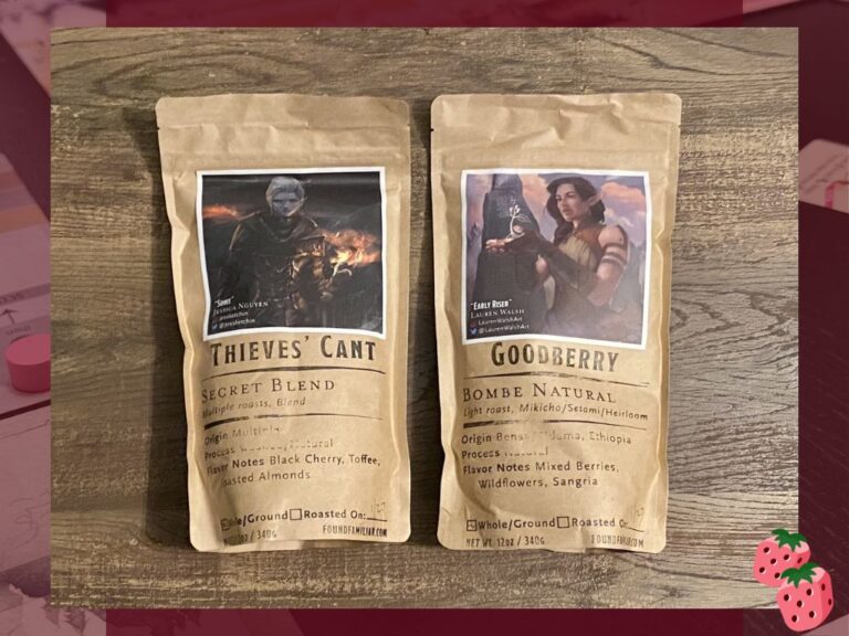 Two bags of coffee beans, one named Thieves' Can't and one named Goodberry are shown on top of a wooden surface. Both include a fantasy drawing.