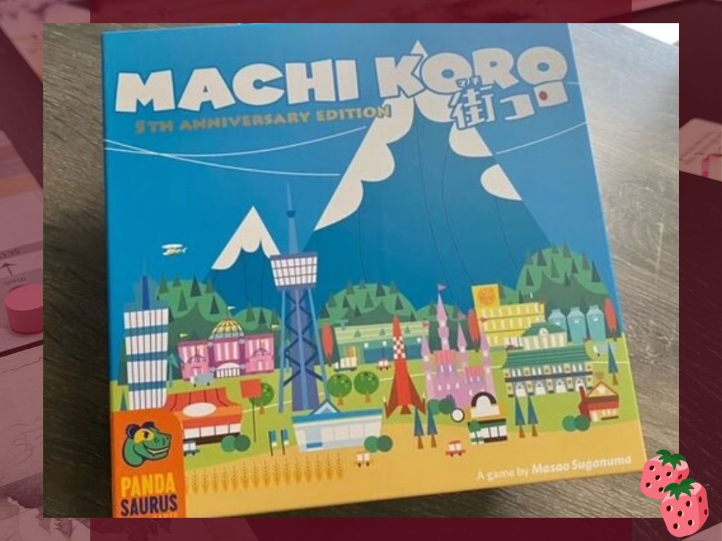A game box reading Machi Koro on top is on display. It states 5th anniversary edition. The Pandasaurus logo is at the bottom left. A colorful town is pictured.