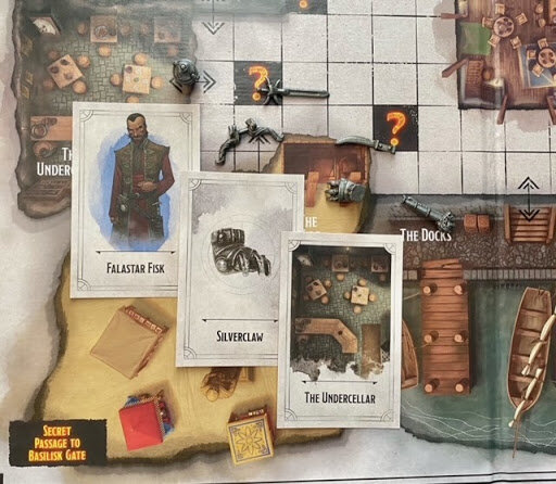 Close-up of Falastar Fisk suspect card, Silverclaw weapon card, and The Undercellar location card arranged on the Dungeons & Dragons Clue game board.