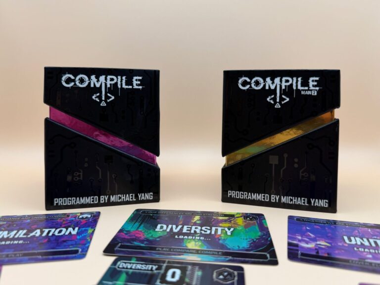 Two boxes for the game Compile set 1 & 2 with protocol cards and their respective command cards underneath. The protocols are assimilation, diversity, and unity.