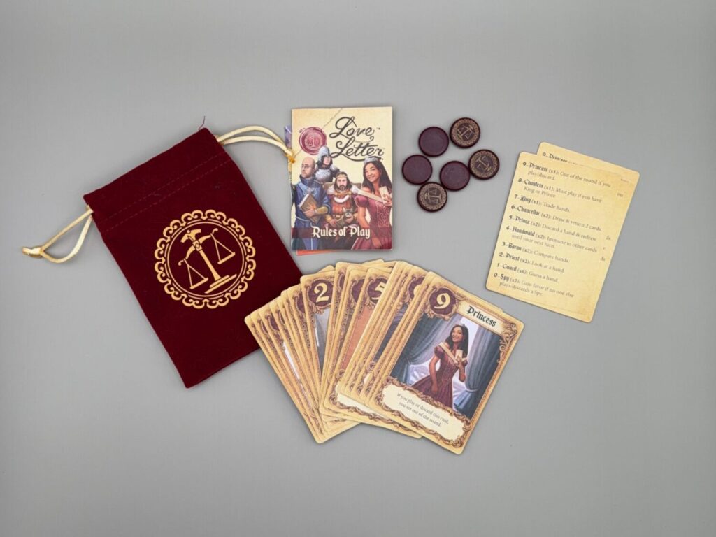 A spread of all the contents of the Love Letter game which includes a red carrying pouch, playing cards, instructions, deep red favor tokens, and six reference cards.