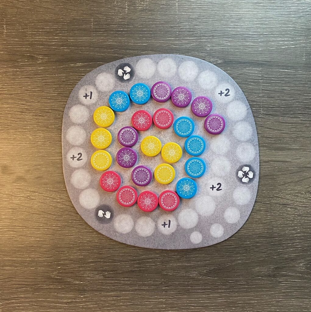 a grayscale game board show colorful stones in a spiral. 