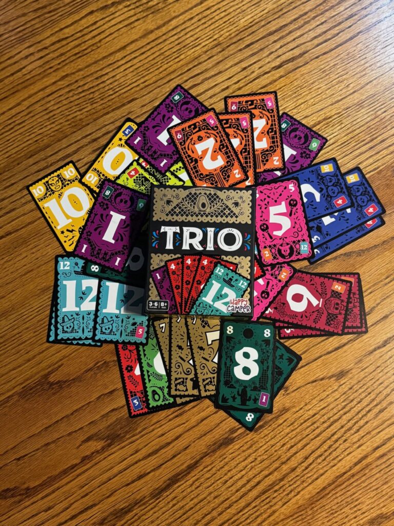 The Trio game box sit on top of a pile of numbered cards. 