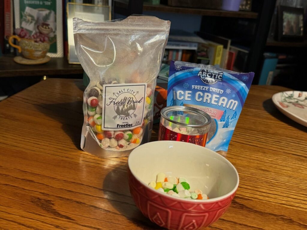 Pictured are bags of freeze dried skittles and freeze dried ice crams. Also in the picture are a red up and red bowl holding candy.
