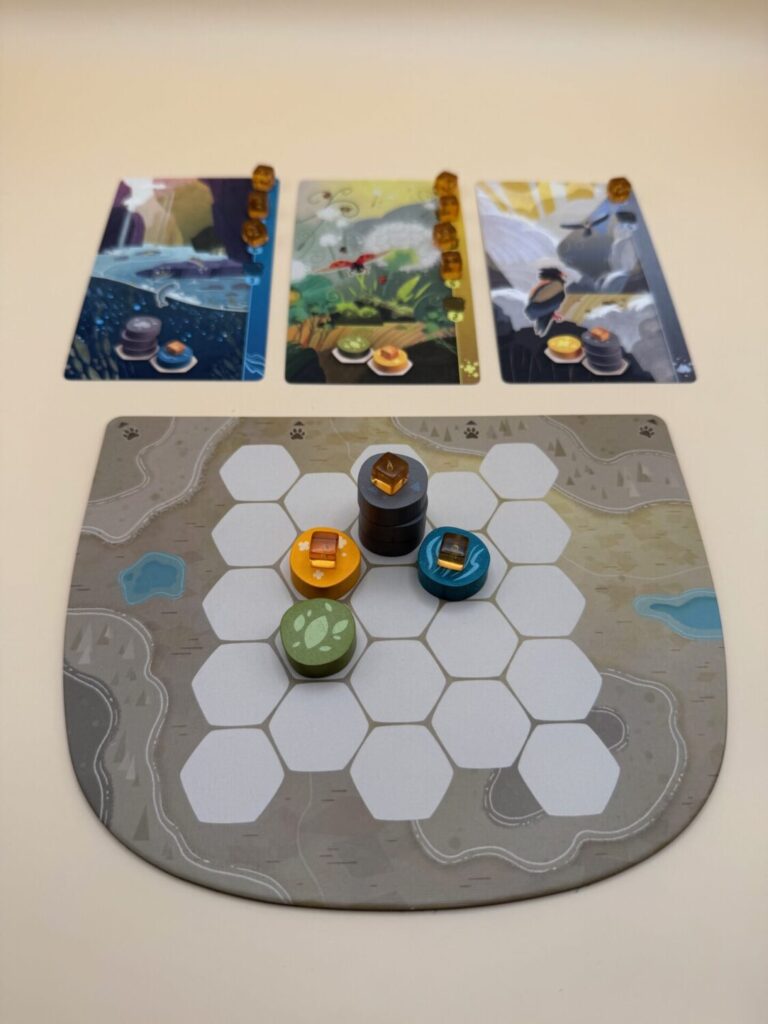 At the top of the image three cards are shown. Below a game board with game tokens is shown.