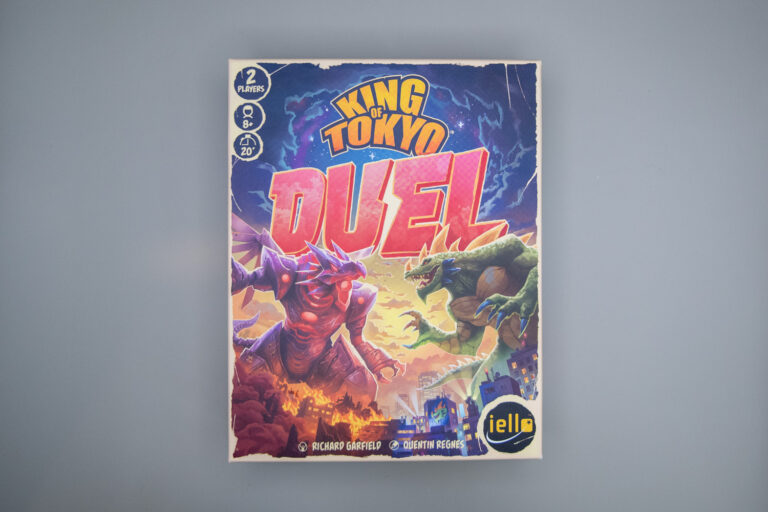 The King of Tokyo Duel game box is shown with two monsters standing off against each other. The iello logo is in the bottom right corner.